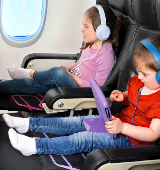 Two young children sit happily on their Bubba Board seat extenders on an airplane