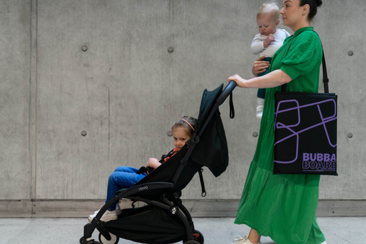 Mother easily walks through airport with two children and her Bubba Board
